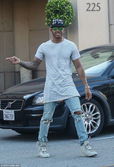 Lewis Hamilton proudly points to his new £145,000 Porsche as he steps out in a longline tee and torn jeans for lunch in Beverly Hills
