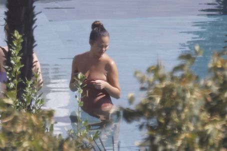 Chrissy Teigen – Seen by a swimming pool in Lake Como
