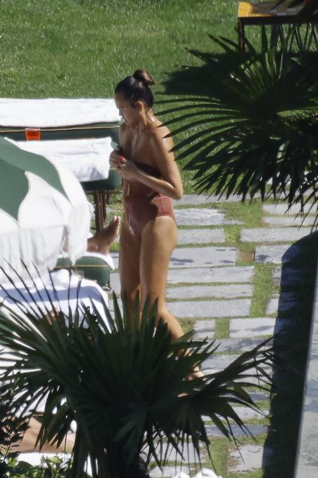 Chrissy Teigen – Seen by a swimming pool in Lake Como