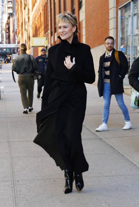 Robin Wright – In a black trench coat and knee long boots in New York