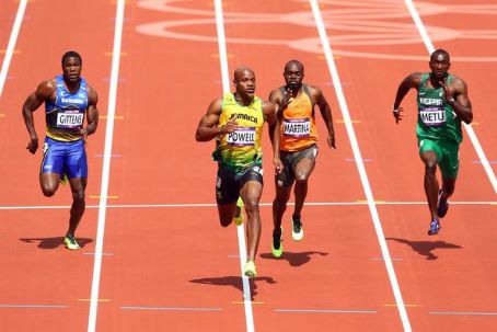 Asafa Powell of Jamaica competes in the Men's 100m Round 1 Heats on Day ...