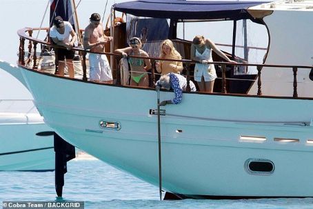 Queen's Roger Taylor uses a pole and shoots an AIRGUN at jellyfish whilst on a boat ride with his wife and children during sun-soaked holiday in Spain
