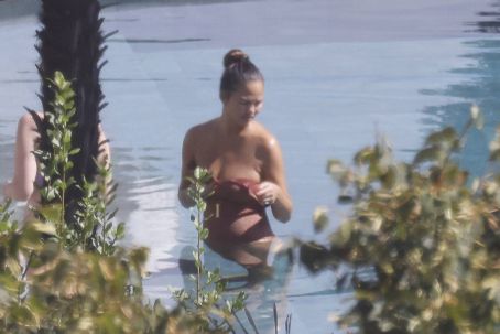 Chrissy Teigen – Seen by a swimming pool in Lake Como